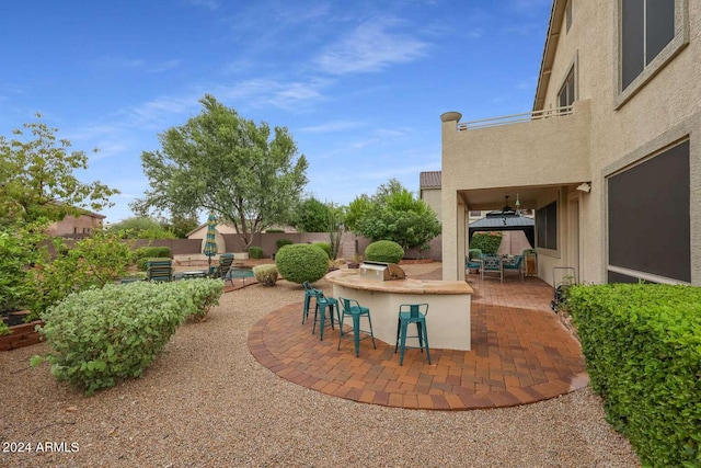 view of patio / terrace featuring ceiling fan and a bar