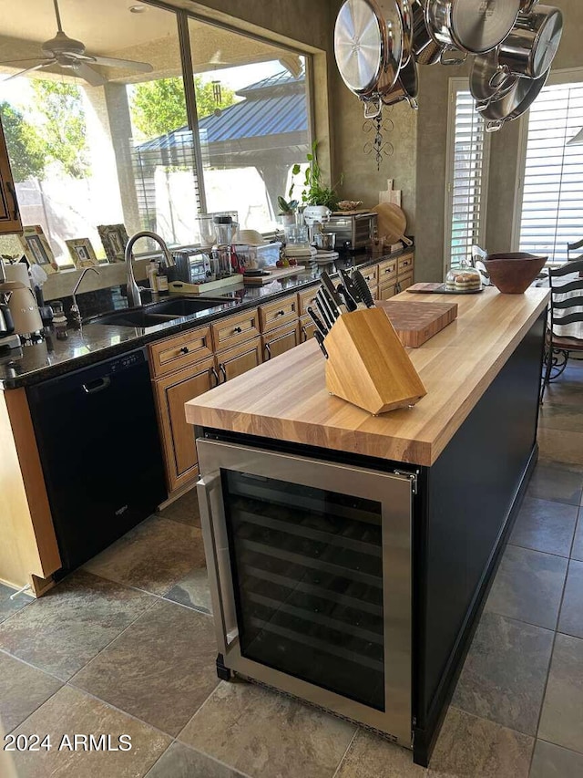 kitchen featuring dishwasher, sink, beverage cooler, and butcher block countertops