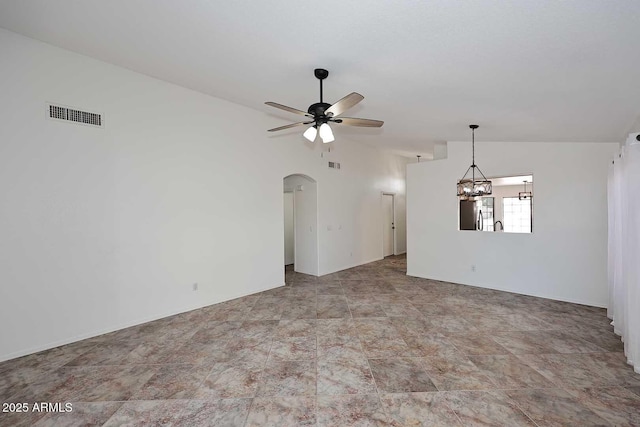 spare room featuring vaulted ceiling, arched walkways, a ceiling fan, and a chandelier