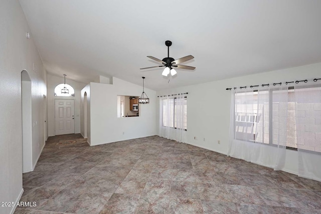unfurnished living room with arched walkways, ceiling fan, vaulted ceiling, and baseboards