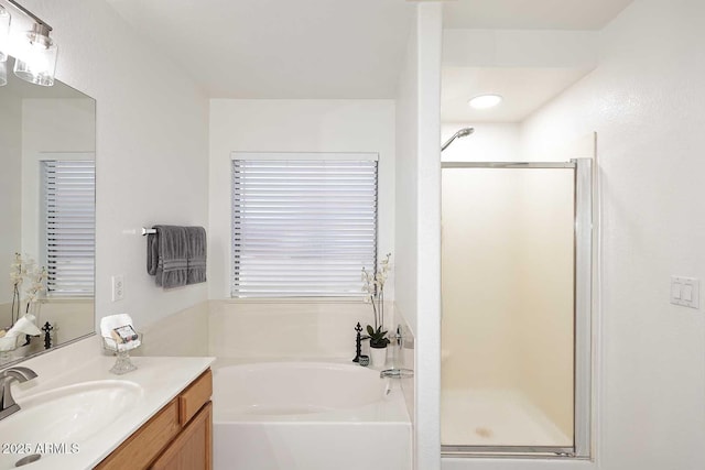 bathroom with a shower stall, a bath, and vanity