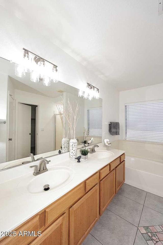 bathroom with tile patterned flooring, double vanity, a garden tub, and a chandelier