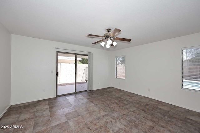spare room with a ceiling fan and baseboards