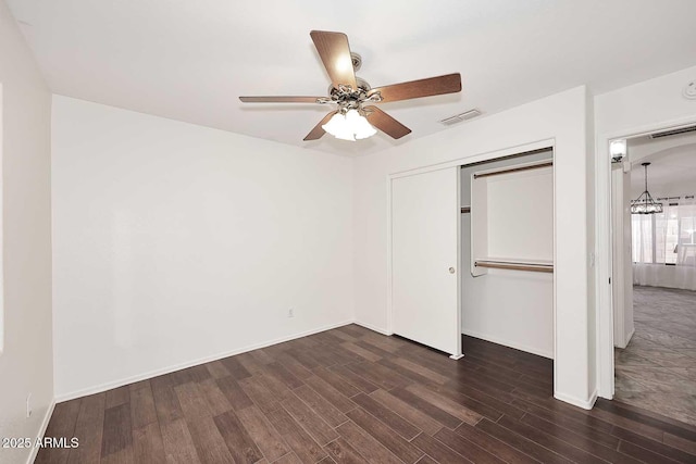 unfurnished bedroom featuring dark wood-type flooring, a closet, baseboards, and ceiling fan