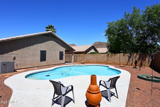 view of pool with a fenced backyard, central AC, and a patio