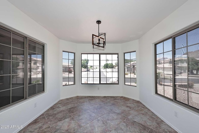 unfurnished sunroom with a chandelier and plenty of natural light