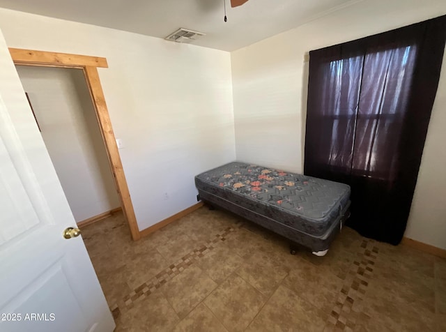 tiled bedroom with a ceiling fan, visible vents, and baseboards
