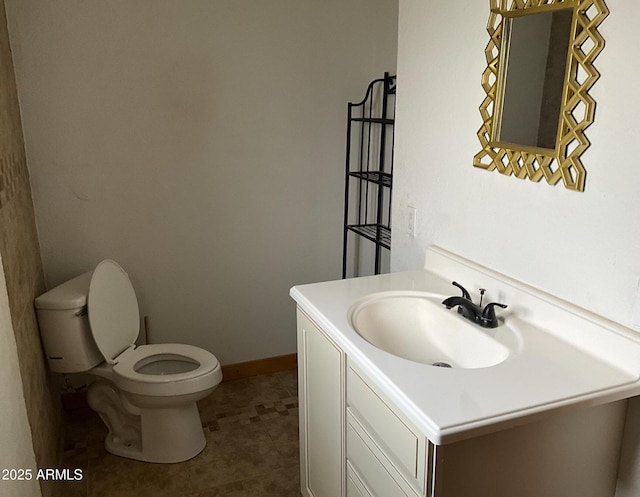 bathroom with toilet, tile patterned flooring, vanity, and baseboards