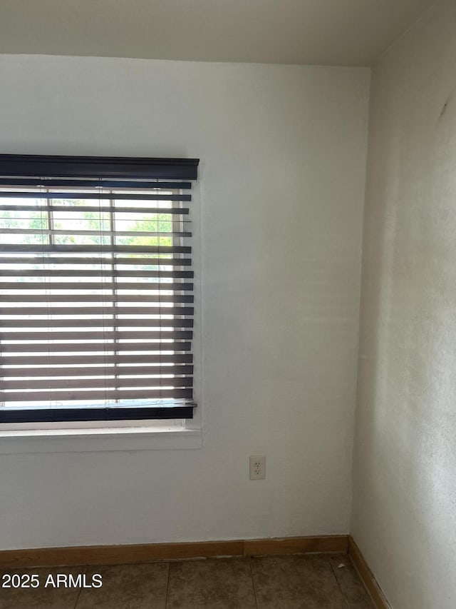 unfurnished room featuring tile patterned flooring and baseboards