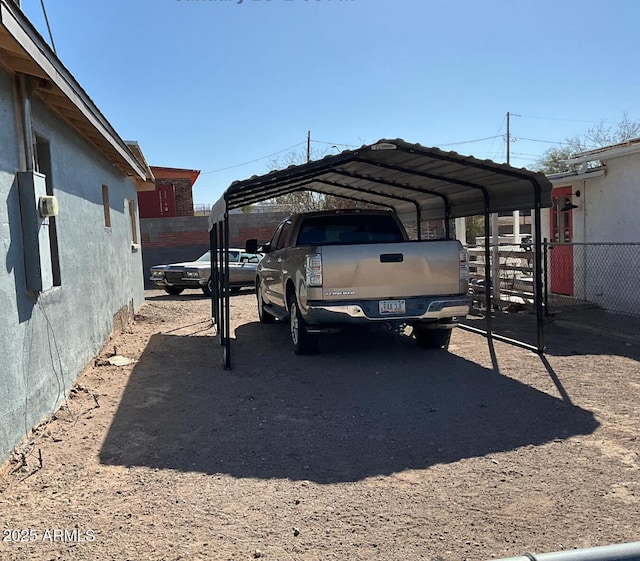 view of car parking featuring fence and a carport