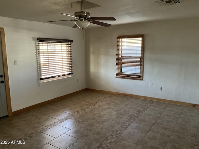 spare room with baseboards, visible vents, ceiling fan, and tile patterned flooring