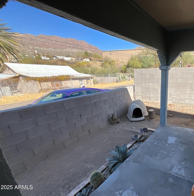 view of patio featuring a mountain view and fence