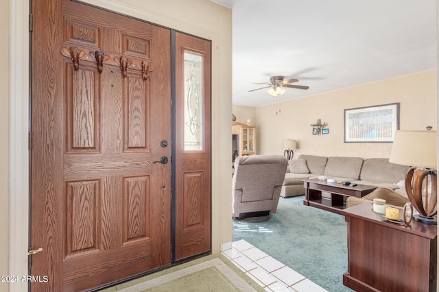 entrance foyer with a ceiling fan and light colored carpet