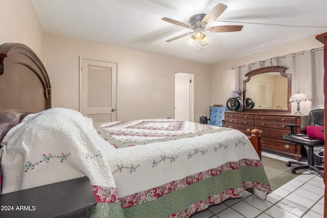 bedroom with ceiling fan, light tile patterned floors, and a closet