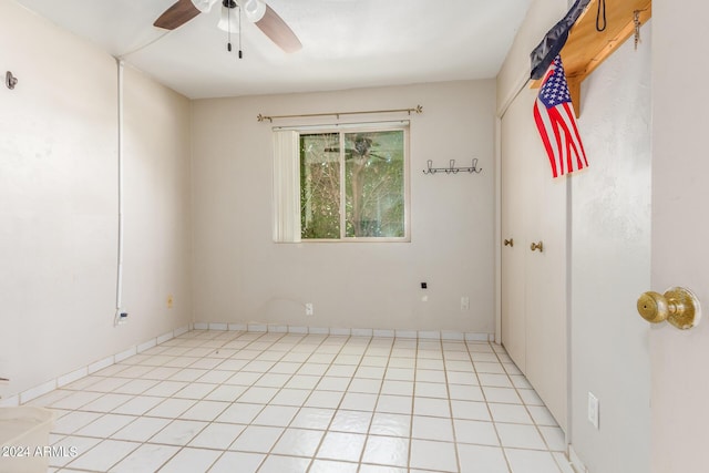 empty room with a ceiling fan and light tile patterned floors