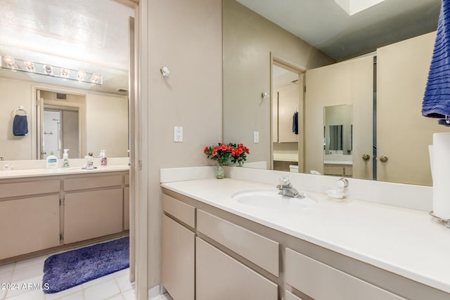 bathroom with two vanities, a sink, visible vents, and tile patterned floors