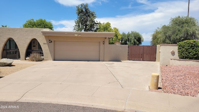 view of front of home with a garage, driveway, fence, and stucco siding