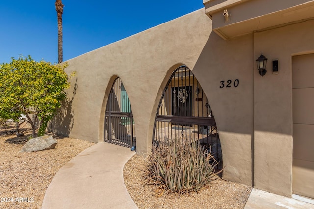 entrance to property with a gate and stucco siding