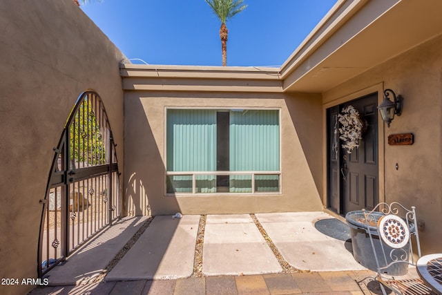 doorway to property featuring a patio and stucco siding