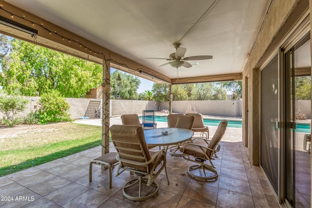 view of patio / terrace with outdoor dining area, a fenced backyard, a ceiling fan, and a fenced in pool