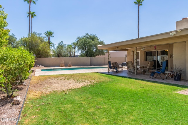 view of yard featuring a patio area, a fenced backyard, a ceiling fan, and a fenced in pool