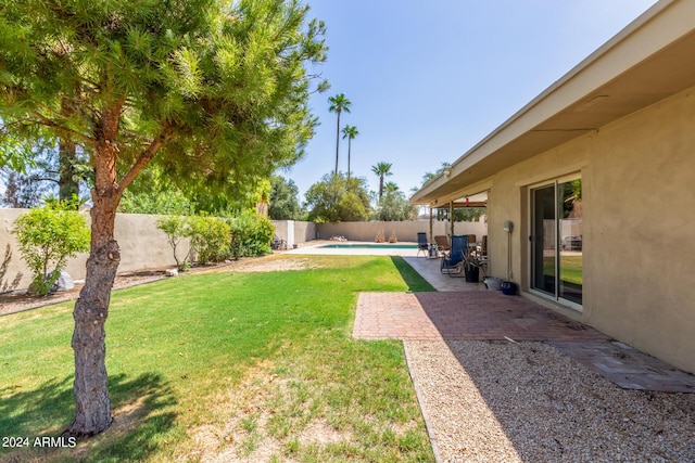 view of yard featuring a fenced in pool, a fenced backyard, and a patio