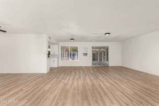 unfurnished living room with ceiling fan and light wood-type flooring