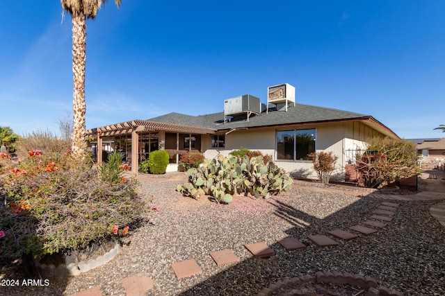 rear view of property with a pergola and central air condition unit