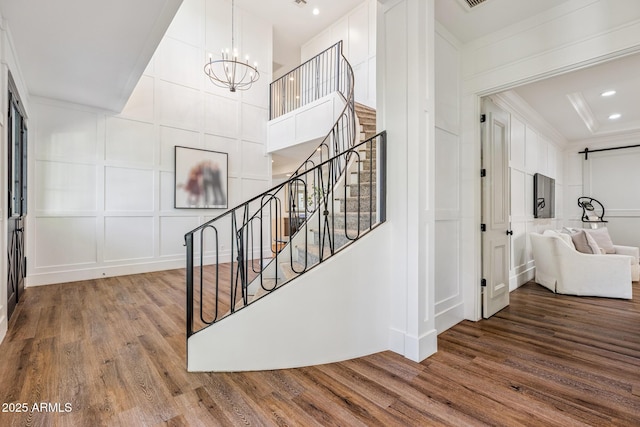 2625 N 24th St Unit 15, Mesa, AZ 85213 - staircase with a decorative wall, wood finished floors, crown molding, and a chandelier