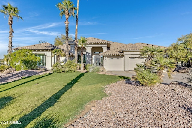 mediterranean / spanish-style house featuring an attached garage, a tile roof, concrete driveway, stucco siding, and a front lawn