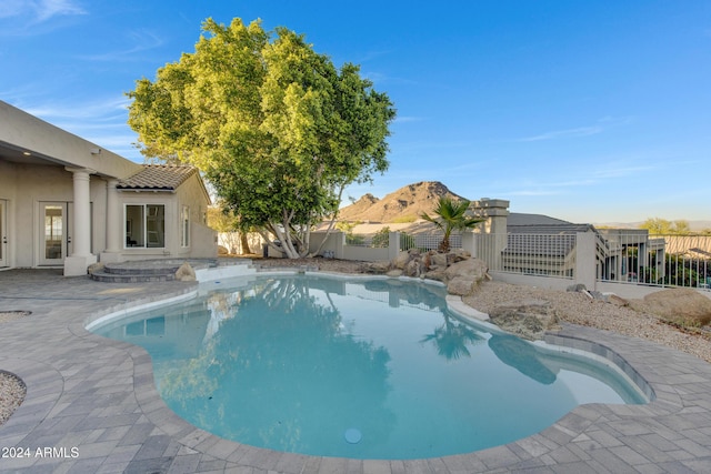 view of pool featuring a fenced backyard, a mountain view, a fenced in pool, and a patio