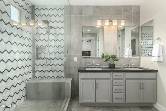 bathroom with a sink, a ceiling fan, walk in shower, and double vanity