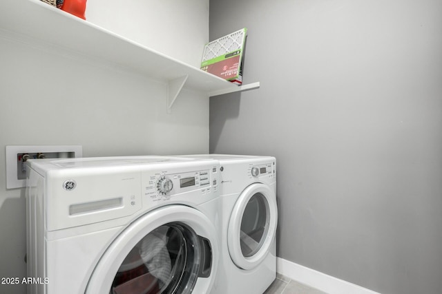 clothes washing area featuring washer and clothes dryer, laundry area, baseboards, and light tile patterned floors