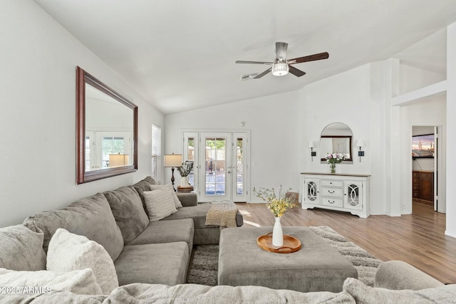 living room with lofted ceiling, light hardwood / wood-style floors, french doors, and ceiling fan