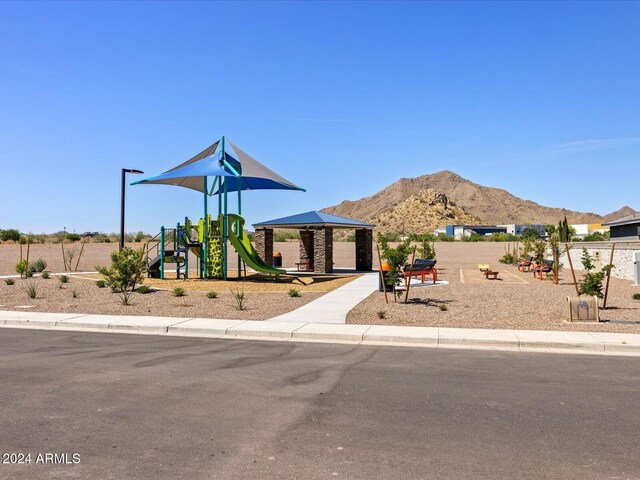 view of front of property featuring playground community and a mountain view