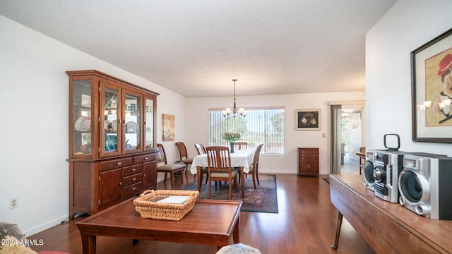 dining space featuring a notable chandelier, dark hardwood / wood-style floors, and a textured ceiling