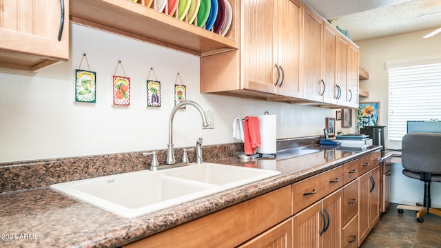 kitchen featuring a textured ceiling and sink