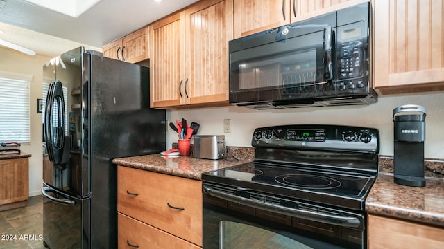 kitchen with black appliances and dark stone countertops