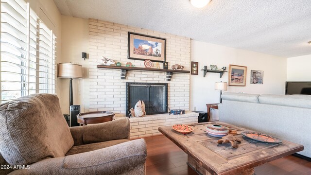 living room featuring a textured ceiling, a fireplace, and dark hardwood / wood-style floors