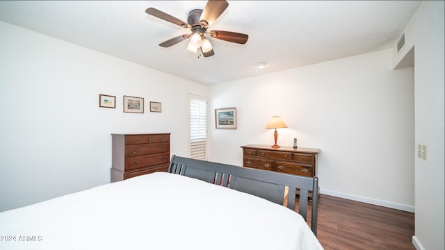 bedroom with a textured ceiling, dark hardwood / wood-style floors, and ceiling fan