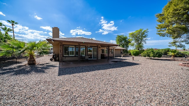 rear view of property with ceiling fan and a patio