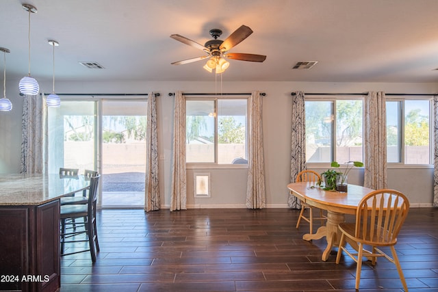 dining area with dark wood-type flooring and ceiling fan