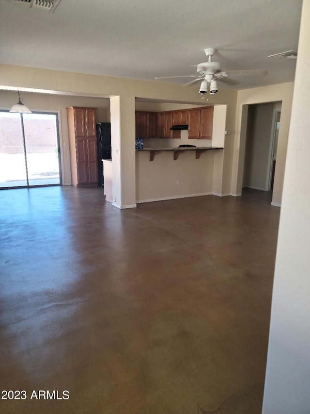 unfurnished living room with finished concrete floors, visible vents, and ceiling fan