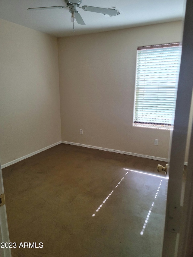 empty room featuring ceiling fan and baseboards