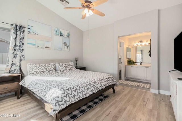 bedroom featuring ceiling fan, ensuite bathroom, light hardwood / wood-style flooring, and vaulted ceiling