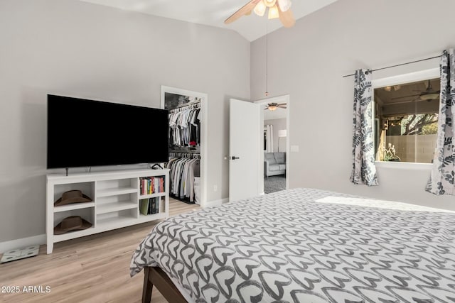 bedroom featuring wood-type flooring, ceiling fan, a walk in closet, a closet, and lofted ceiling