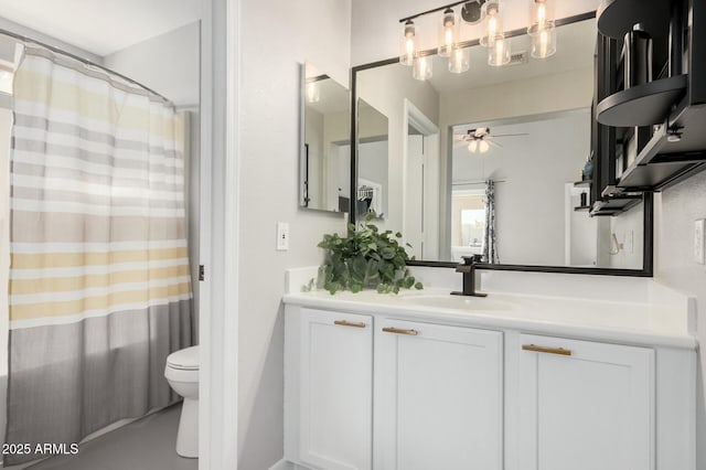 bathroom with vanity, toilet, and ceiling fan