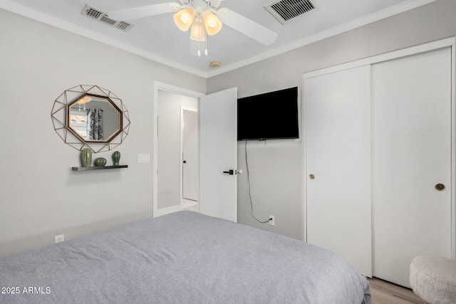 bedroom with light wood-type flooring, ceiling fan, and ornamental molding