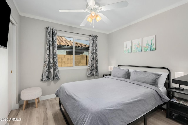 bedroom featuring ceiling fan, hardwood / wood-style floors, and crown molding