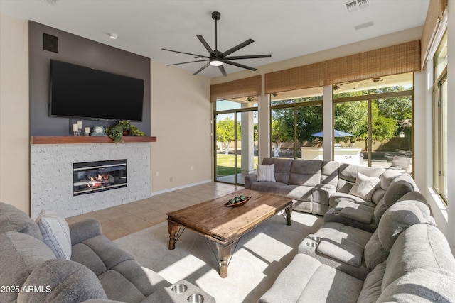 3410 E Inglewood Cir, Mesa, AZ 85213 - tiled living area featuring ceiling fan, visible vents, a stone fireplace, and plenty of natural light